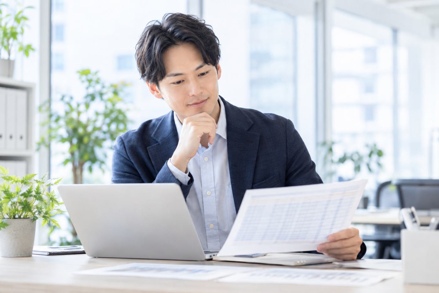 事務所で管理物件の入居状況と空室データを確認する賃貸管理会社の担当者の写真イメージ